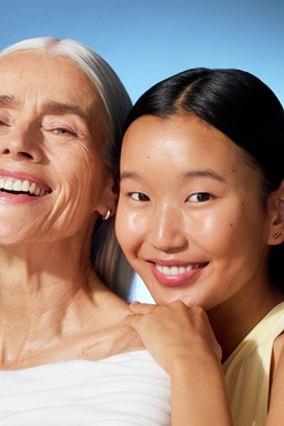 a young woman and an old lady smiling to the camera