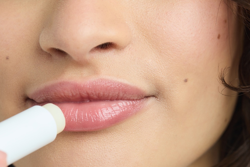 Young woman using NIVEA Hyaluron Moisture Plus Lip Balm