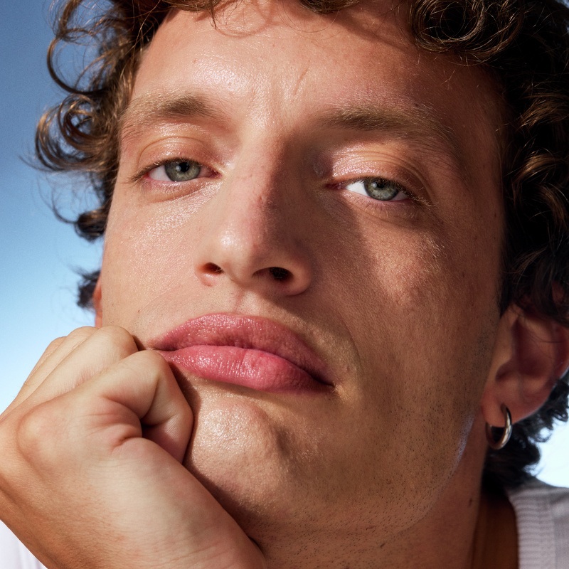 young man looking into the camera with his hand under his chin
