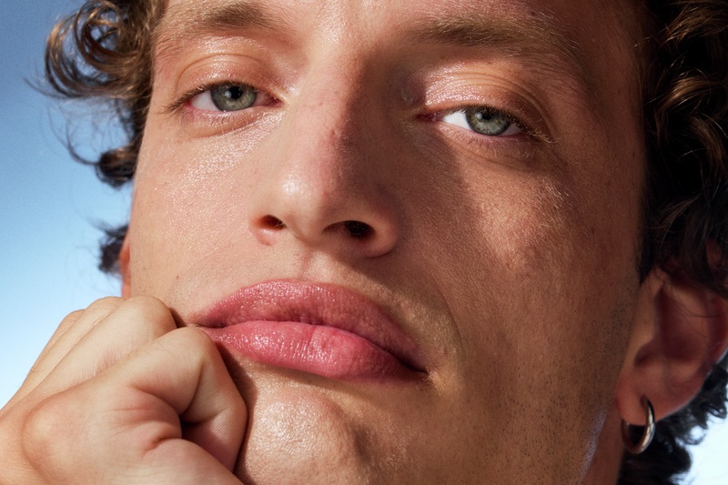 young man looking into the camera with his hand under his chin