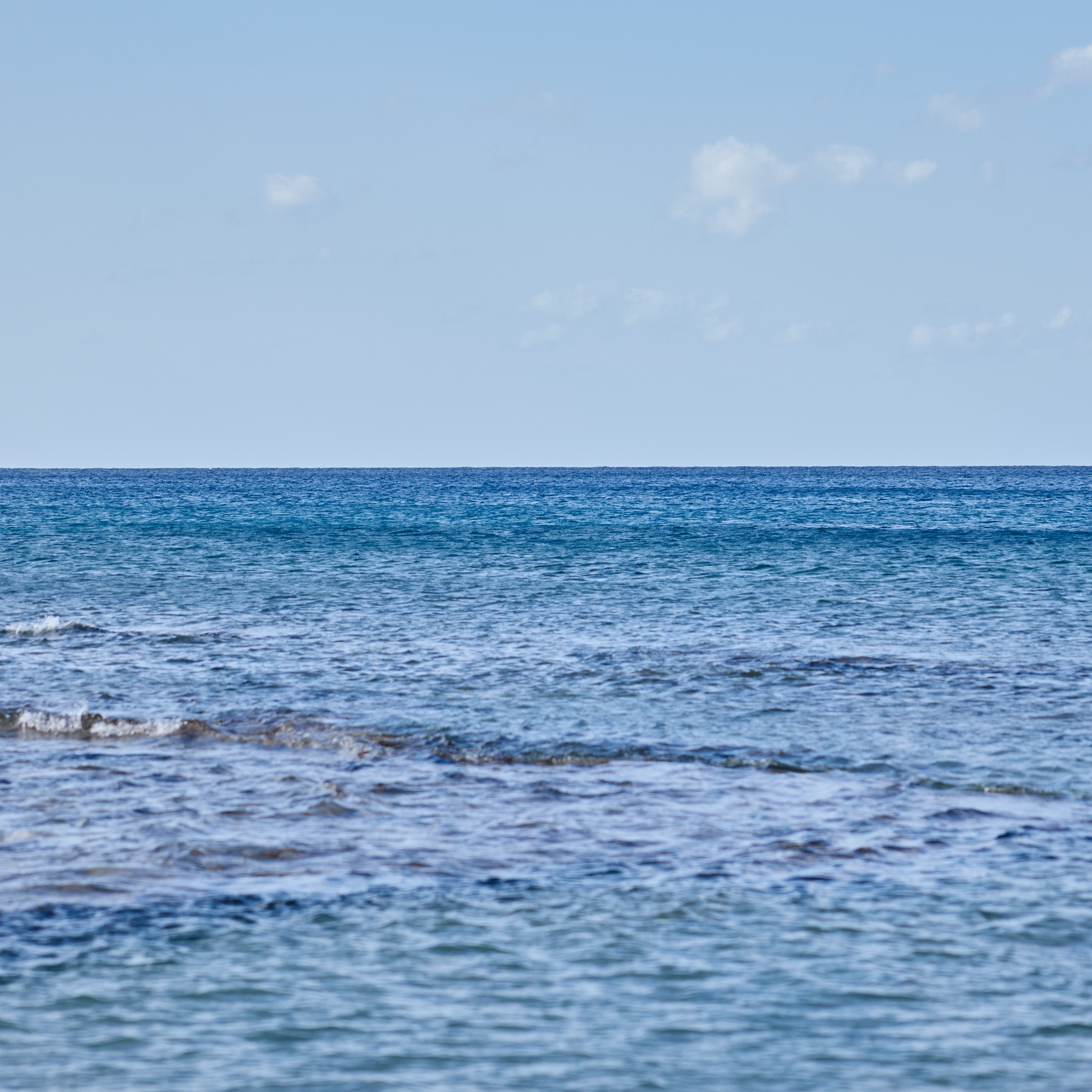 An outdoor view of the ocean with azure water and wind waves