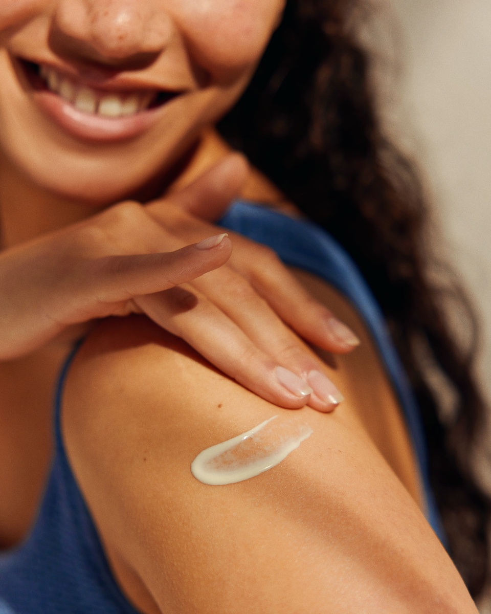 Young woman applying Nivea sun lotion