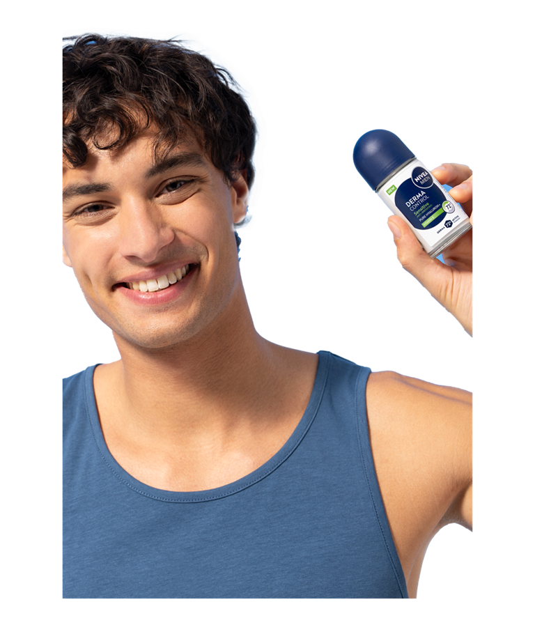 A young smiling man smiles while holding up NIVEA MEN Derma Control Sensitive Deo Roll-On.