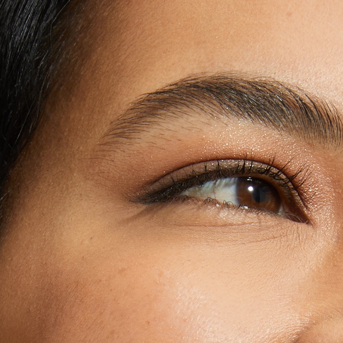 A close-up of a woman's eye and smooth cheek area.