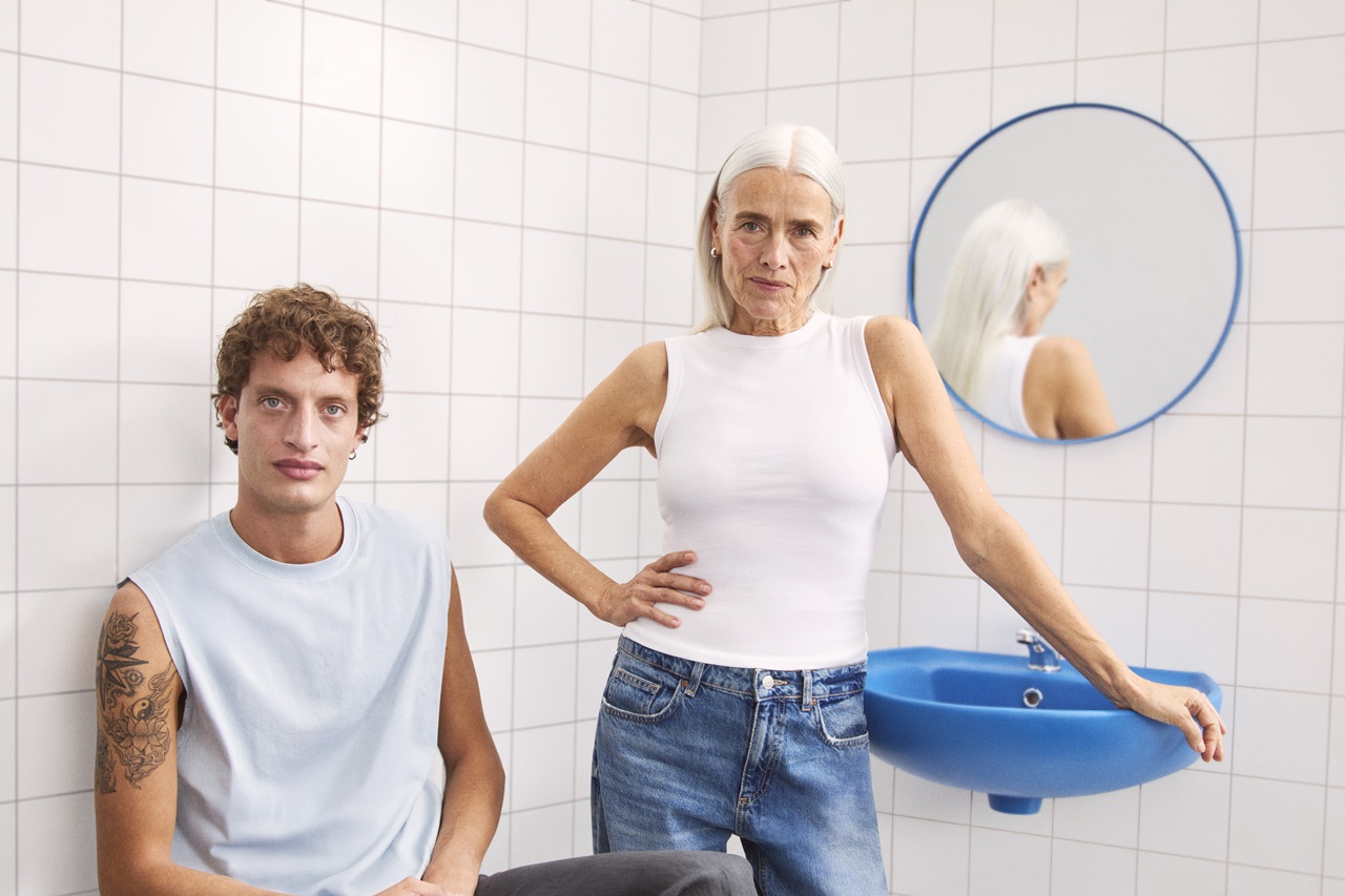 young man and a lady sitting in the bathroom looking to the camera