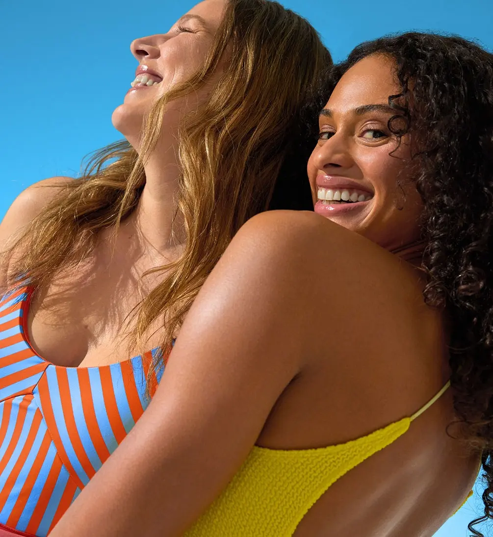 Two women smiling and enjoying the sunshine under a clear blue sky.