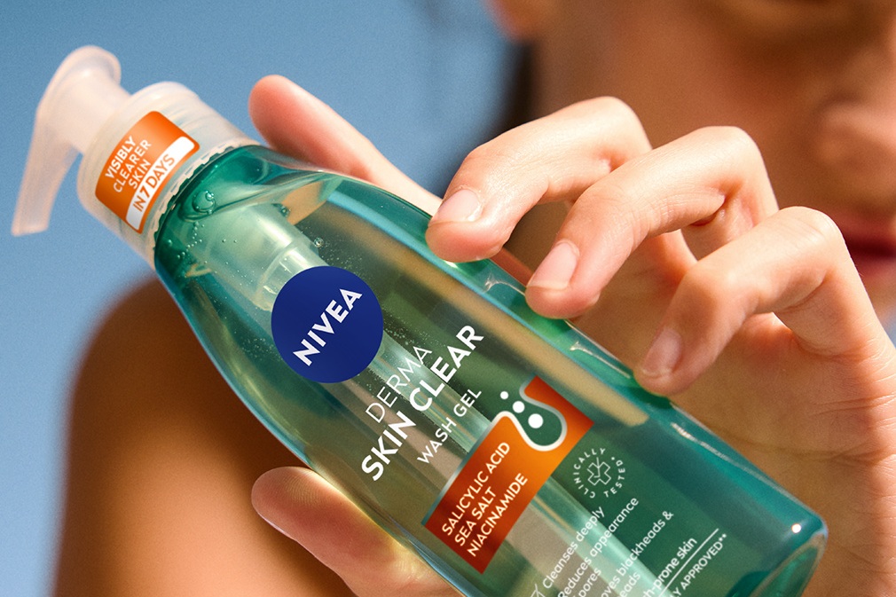 woman holding the NIVEA Derma skin clear face wash bottle in hand