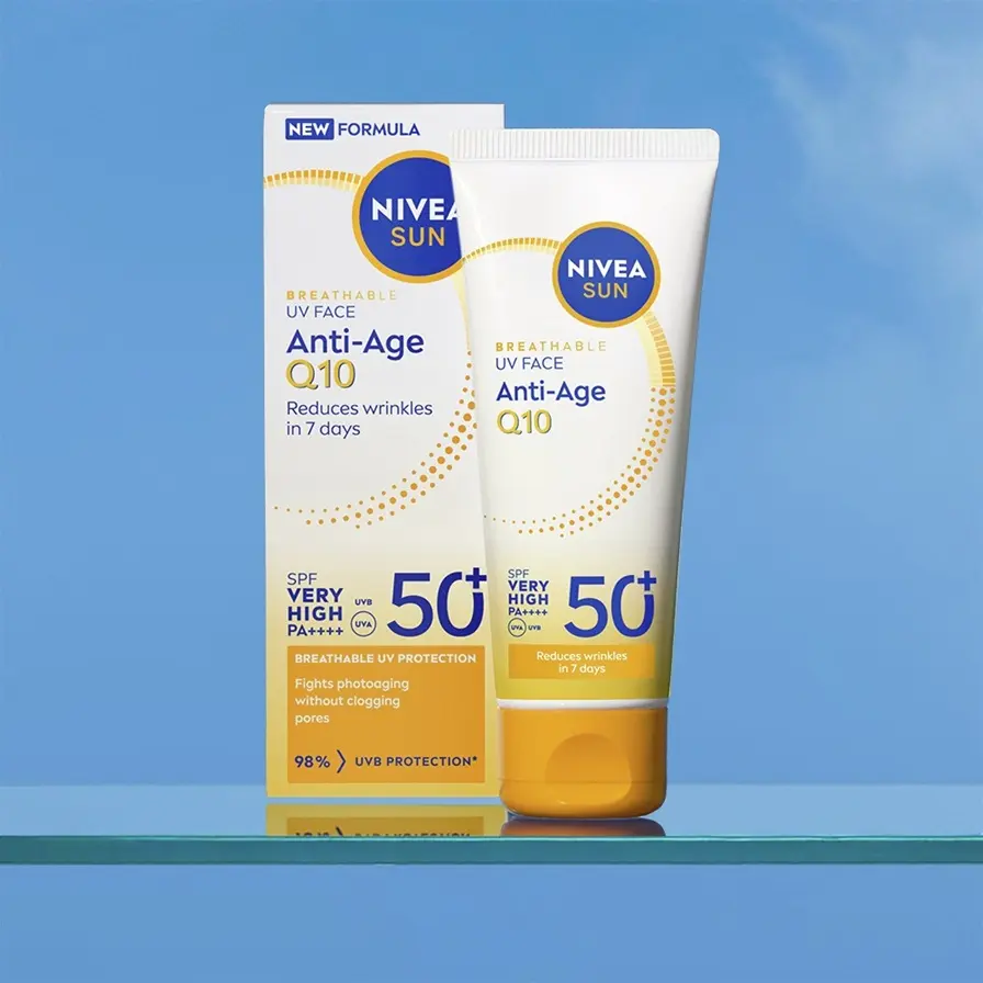 NIVEA Sun Anti-Age Q10 UV face cream SPF 50+ tube and box on a glass shelf against a blue background