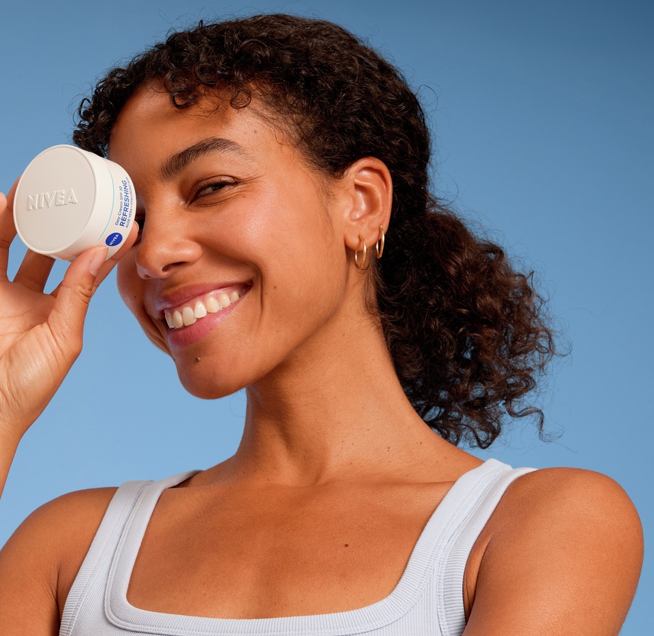 Young woman using Nivea face cream