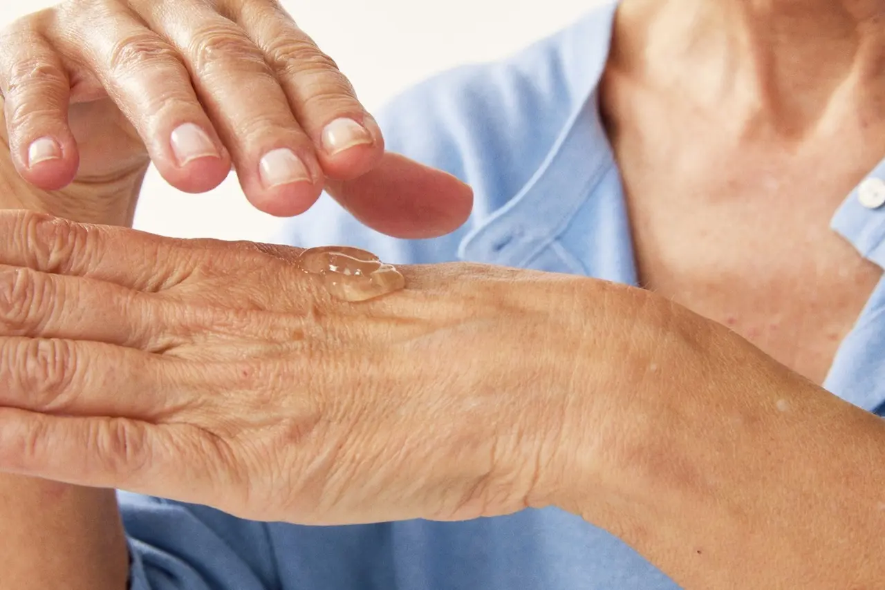 hands of an old person with some serum on it