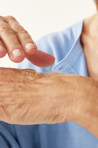 hands of an old person with some serum on it