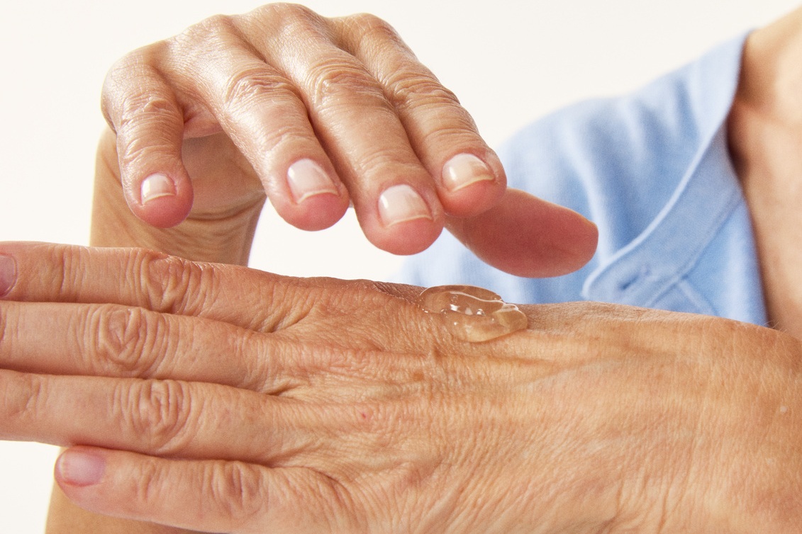 hands of an old person with some serum on it