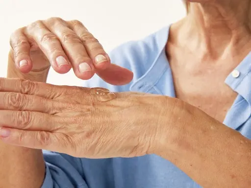 hands of an old person with some serum on it