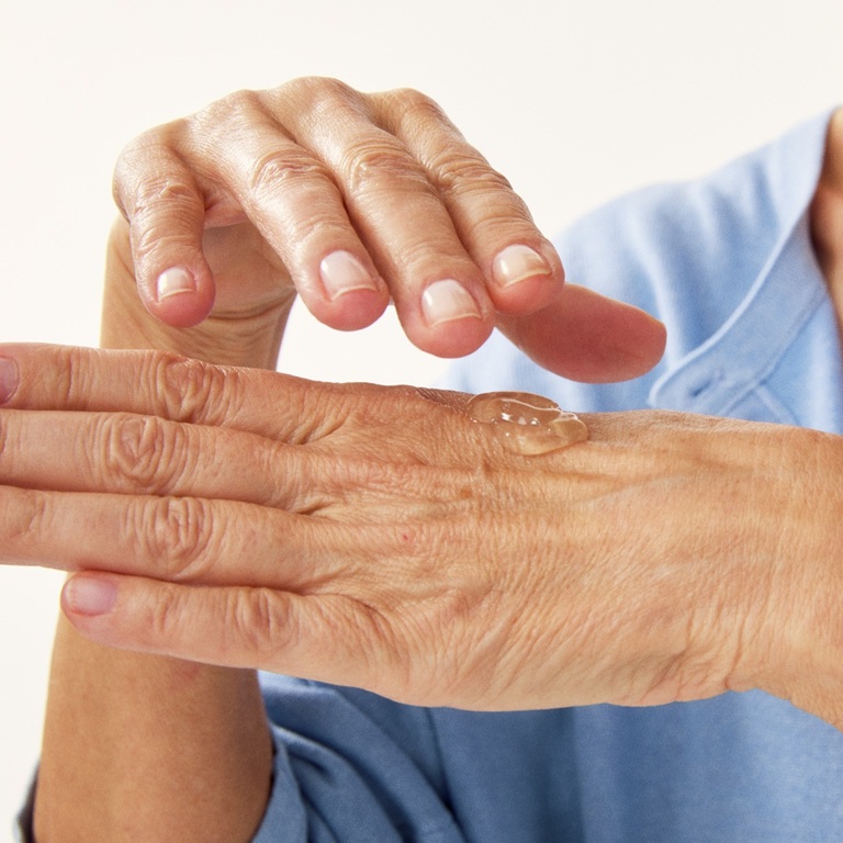 hands of an old person with some serum on it