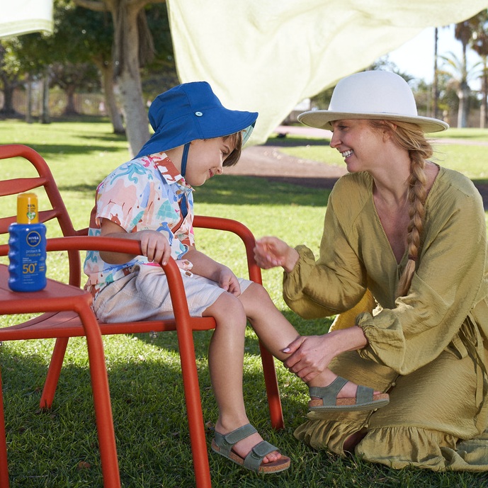 Woman and child applying sunscreen