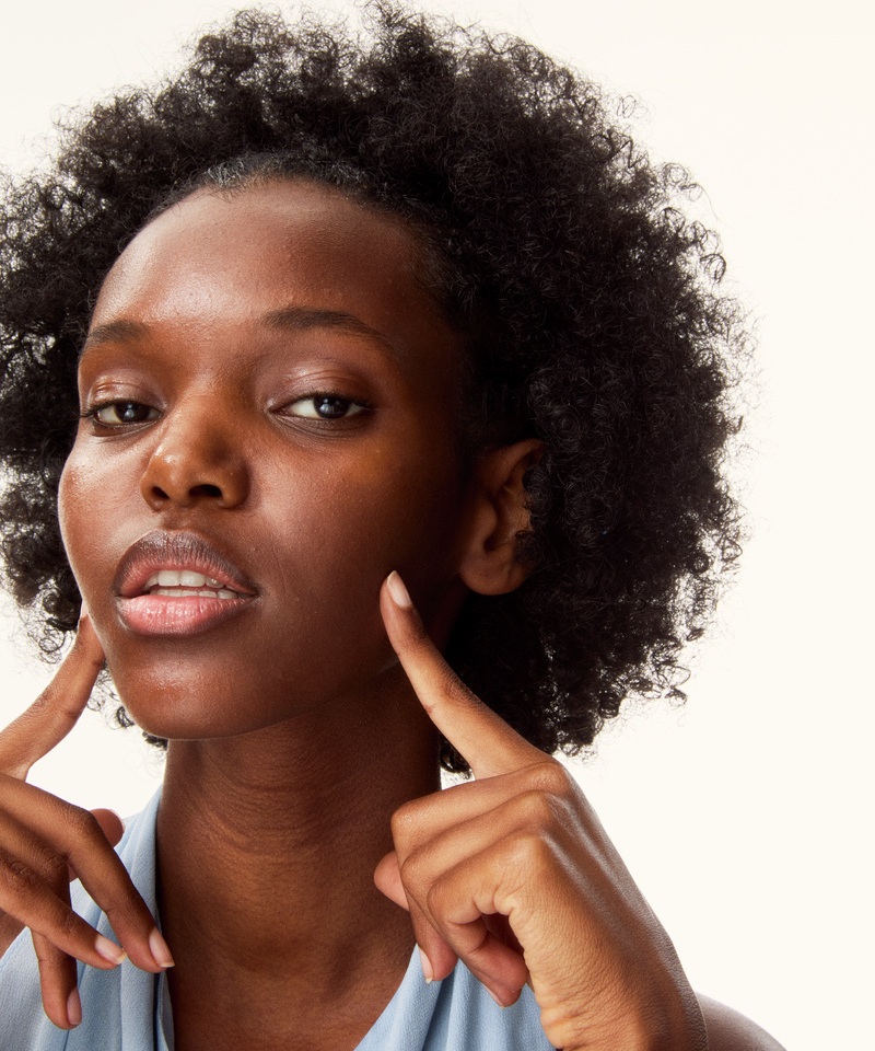 young woman pointing her fingers to her own face