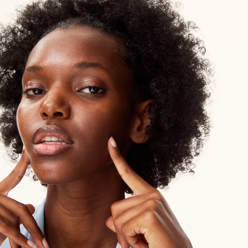 young woman pointing her fingers to her own face