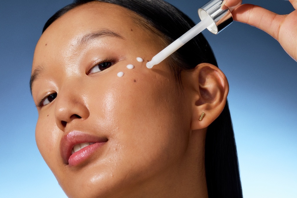 young woman applying serum