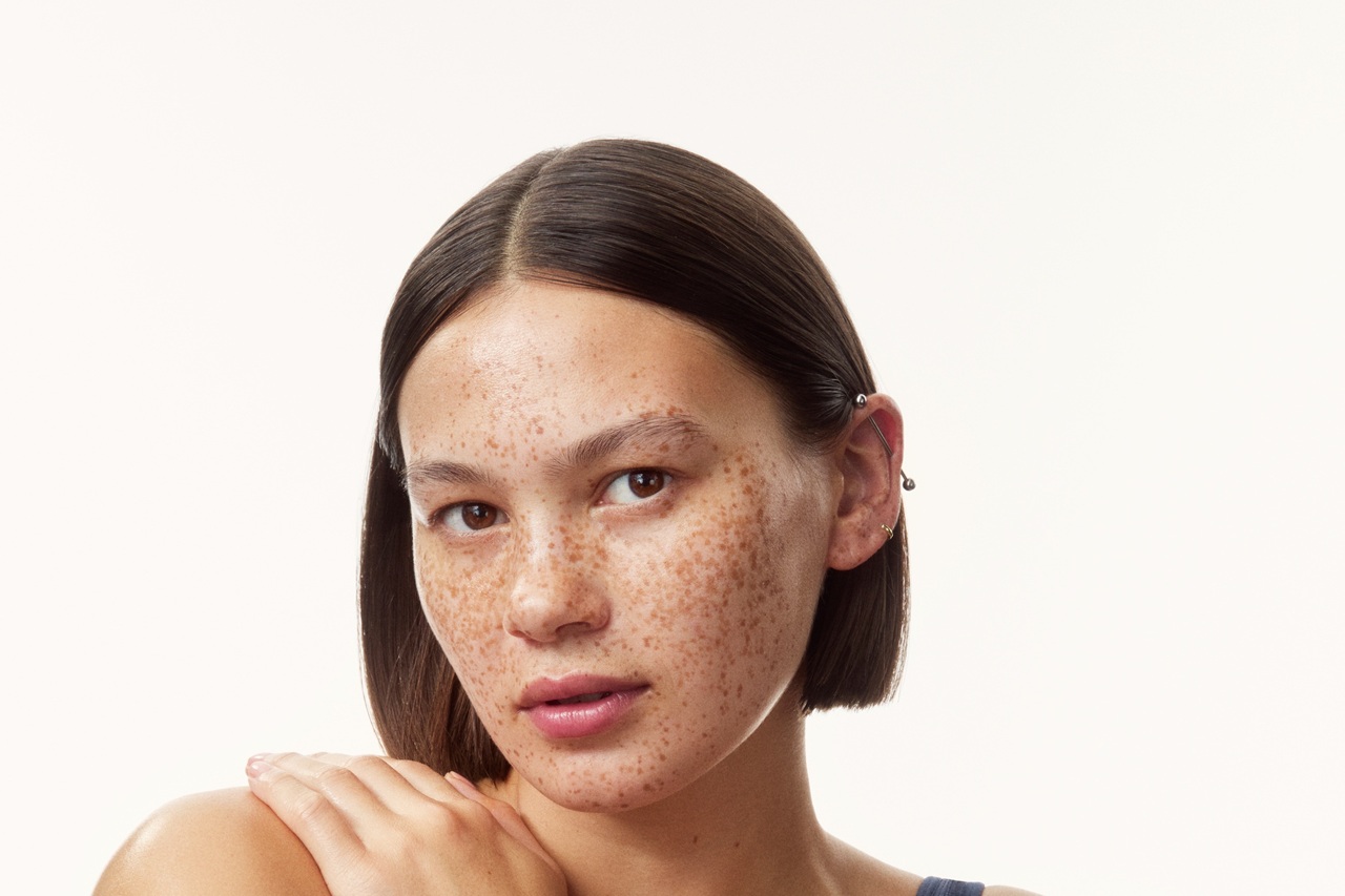 young girl in a top with creams all over her arms