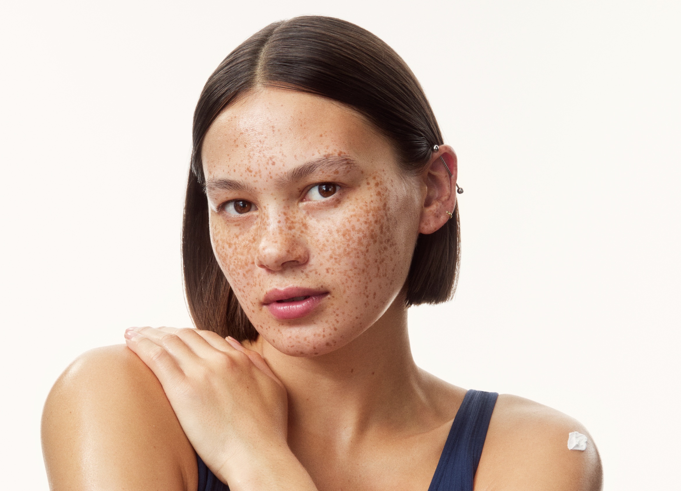 young girl in a top with creams all over her arms