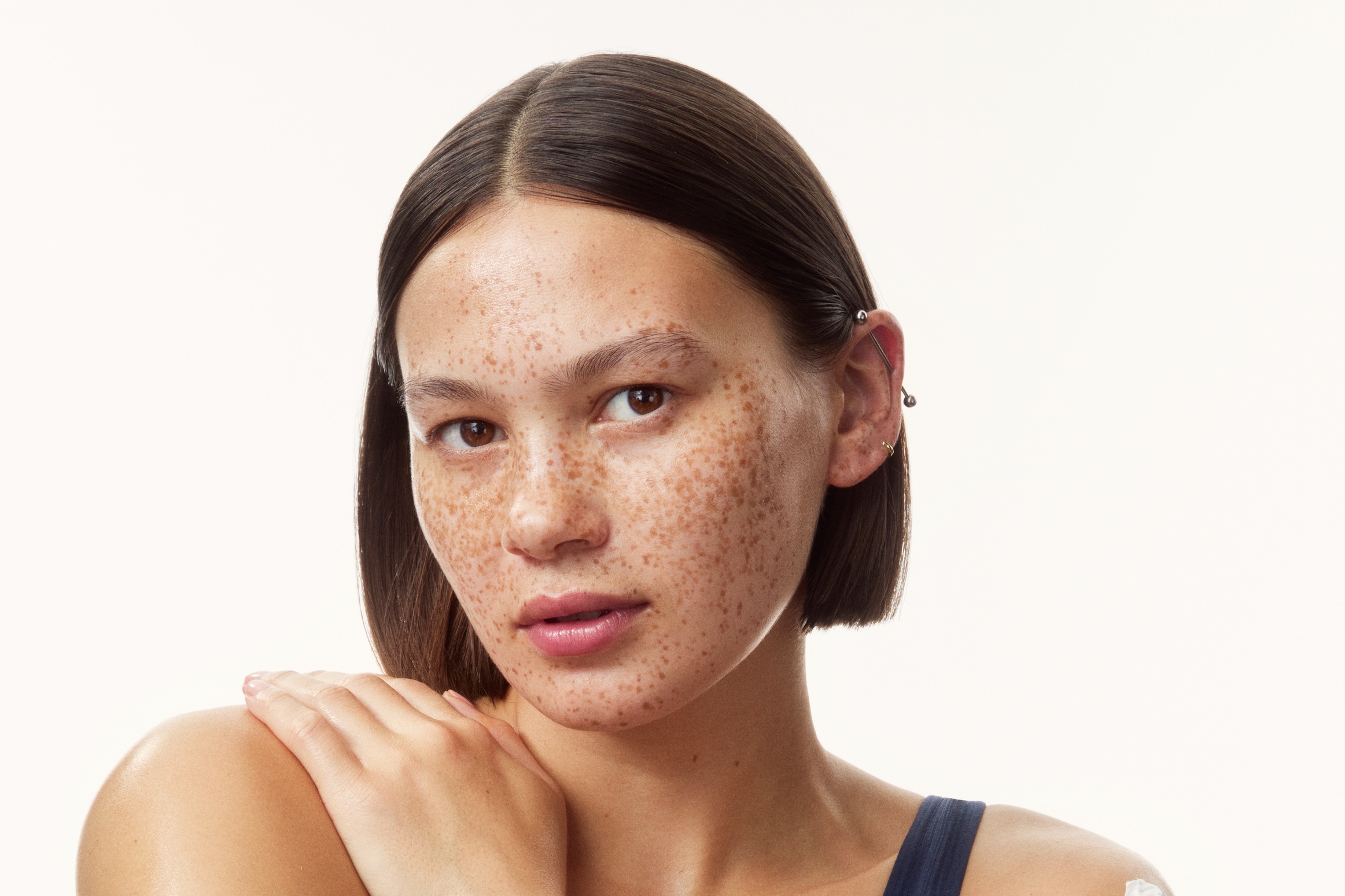 young girl in a top with creams all over her arms