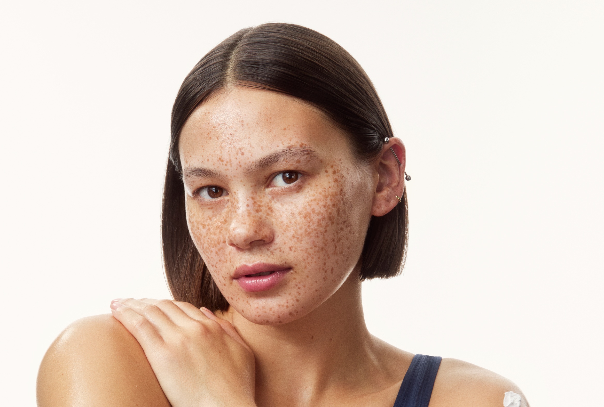 young girl in a top with creams all over her arms