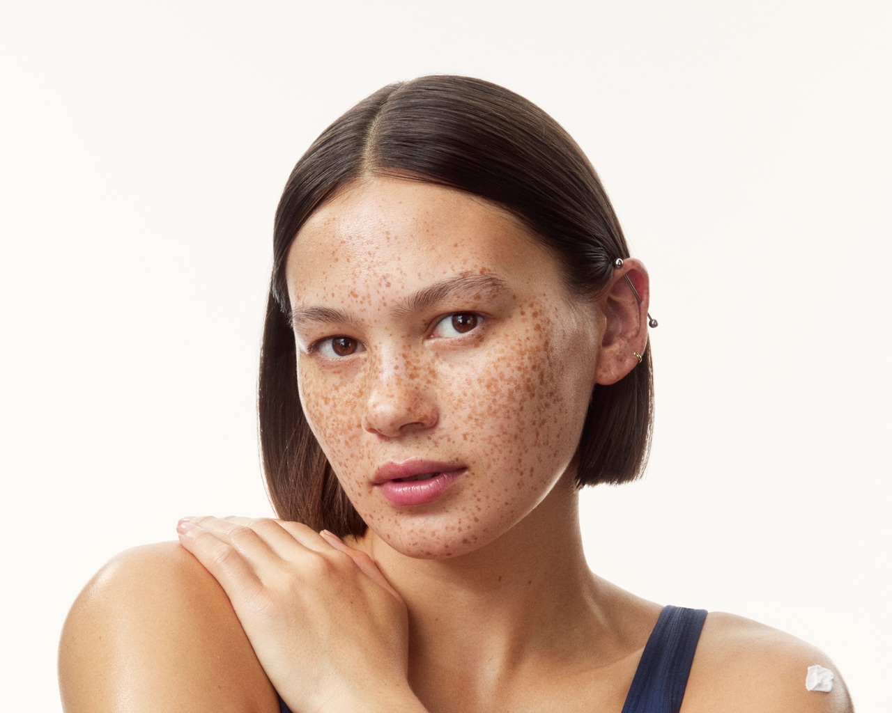 young girl in a top with creams all over her arms