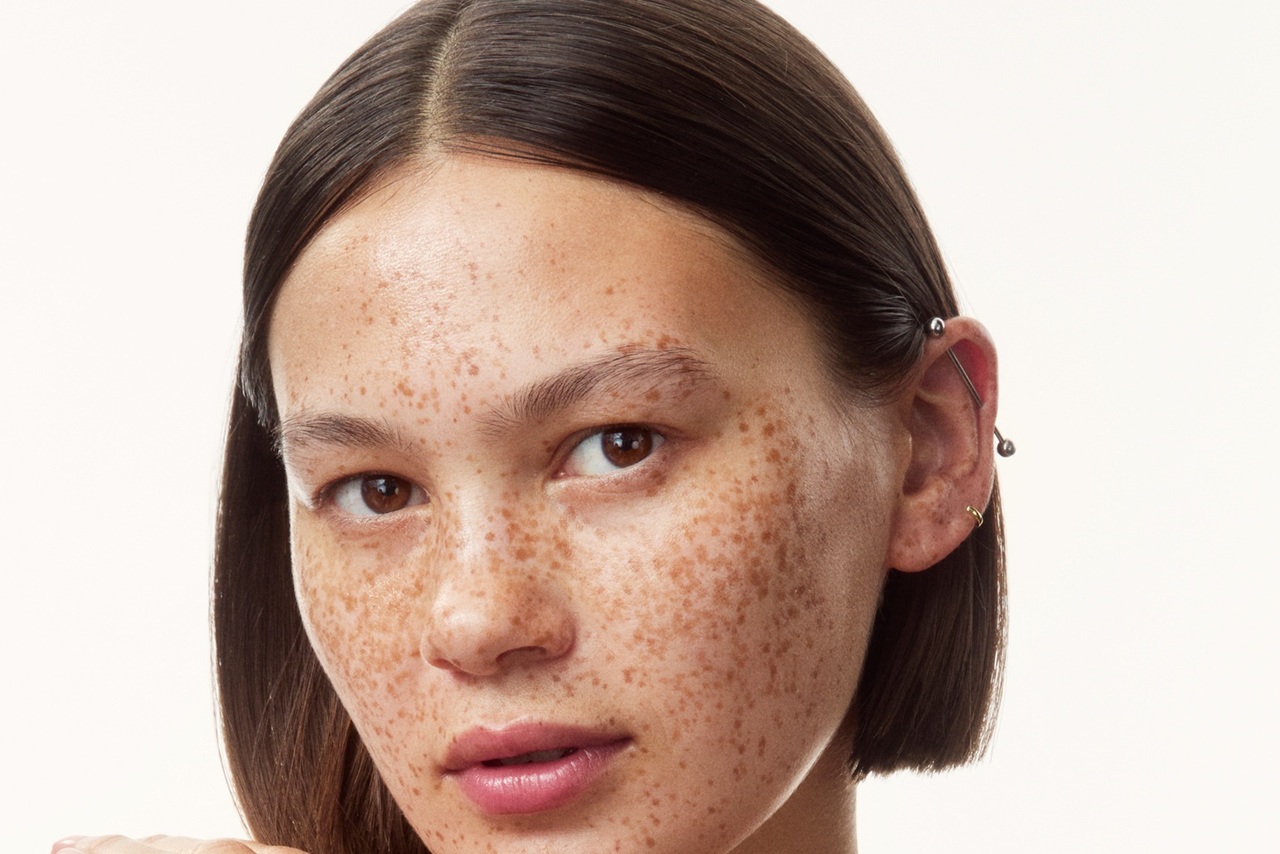 young girl in a top with creams all over her arms