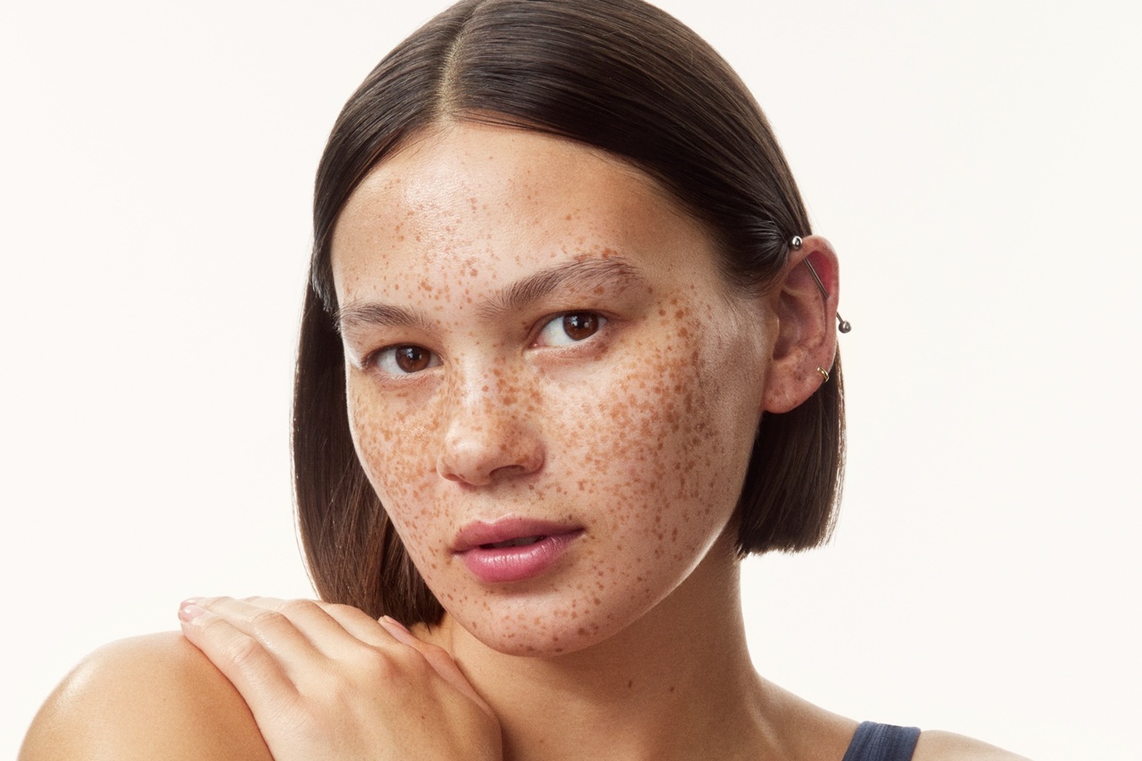 young girl in a top with creams all over her arms