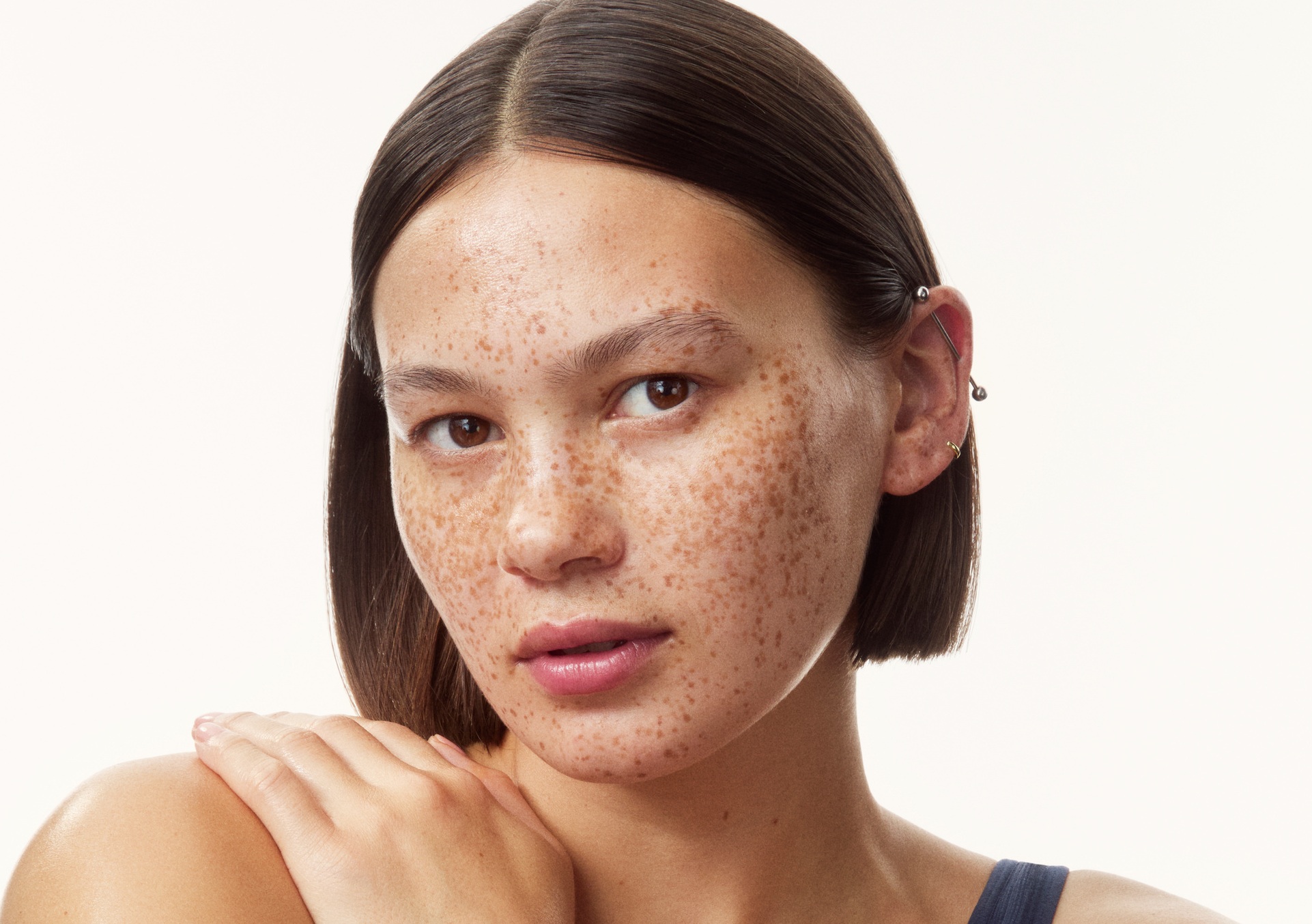young girl in a top with creams all over her arms