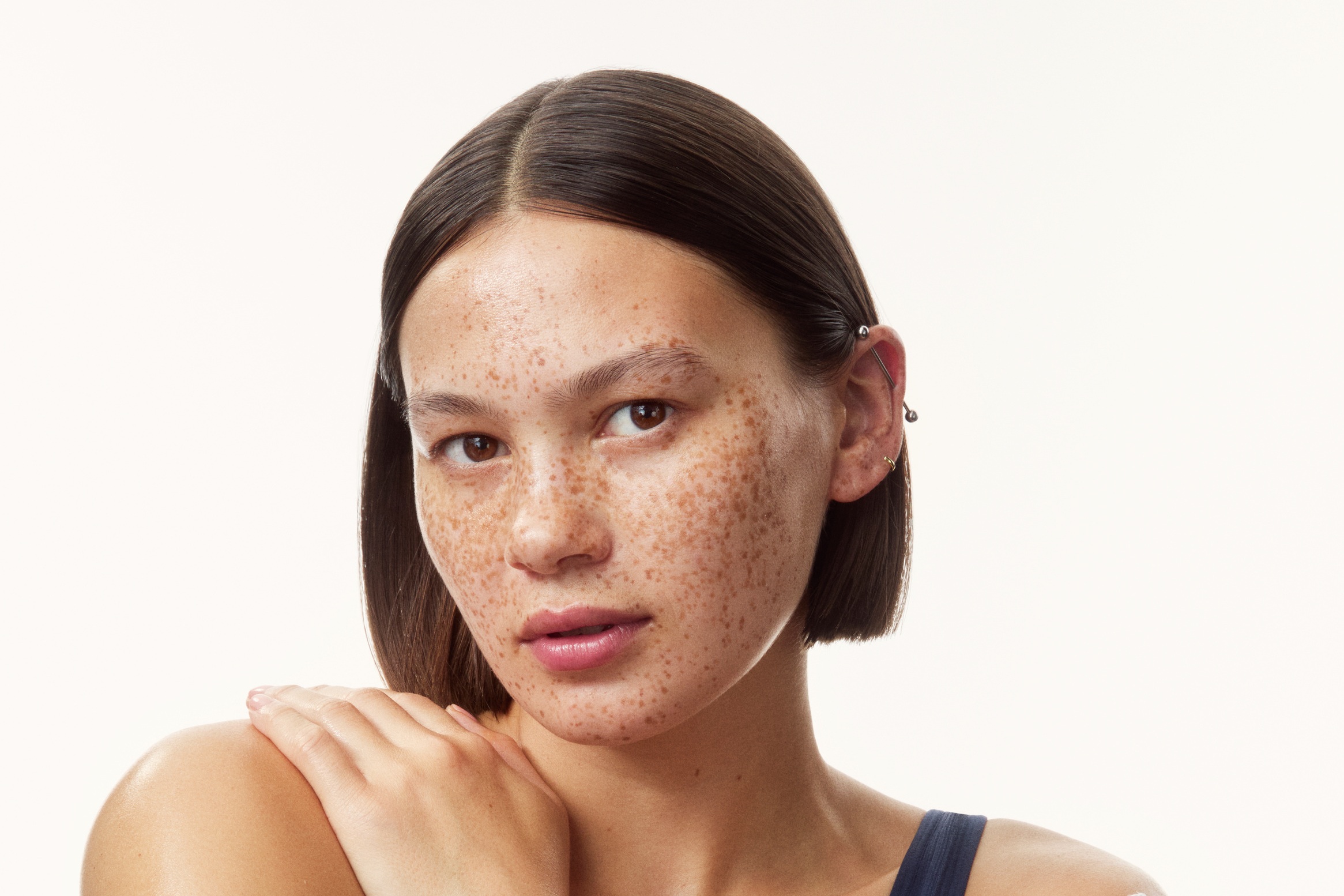 young girl in a top with creams all over her arms