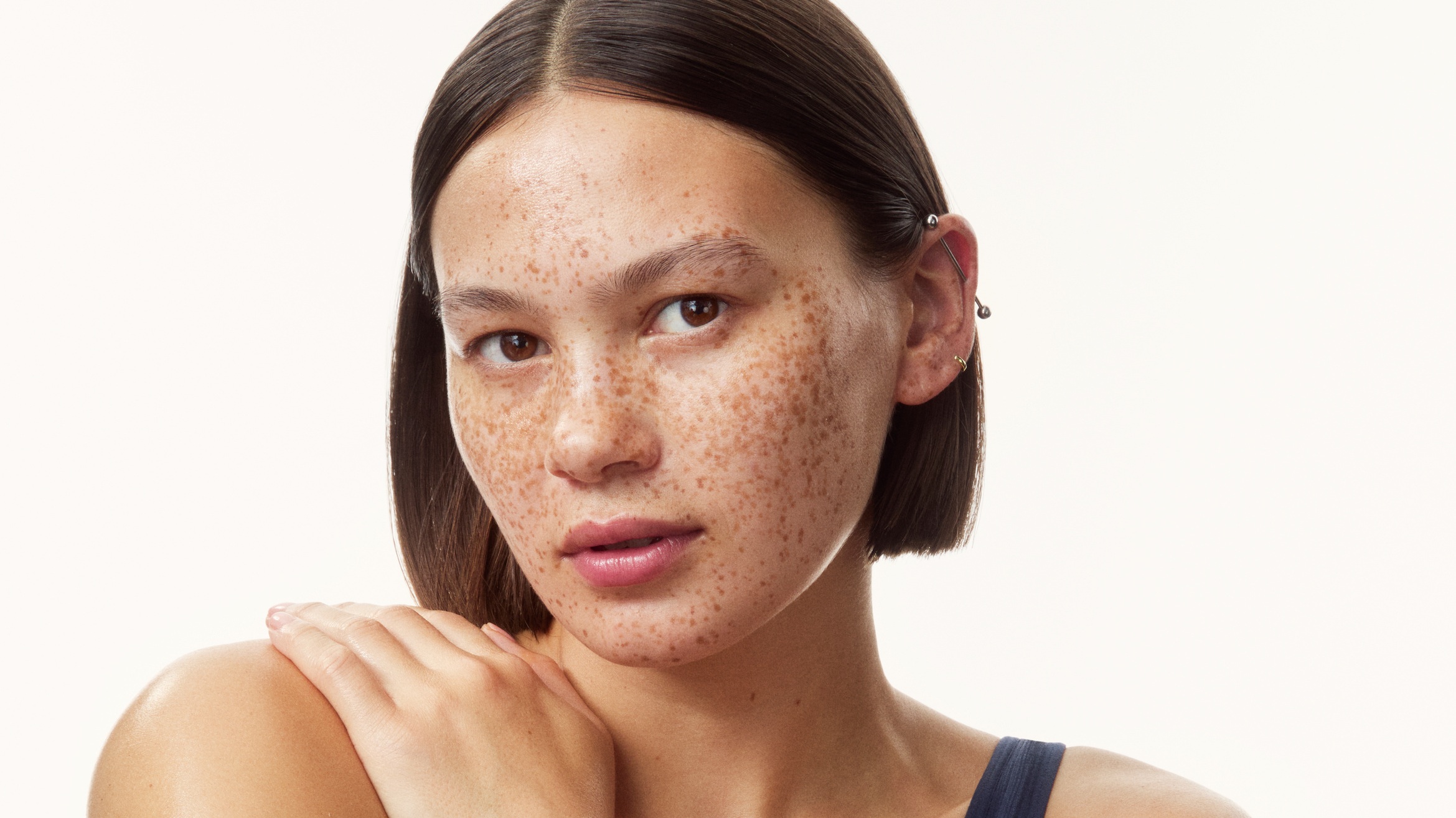 young girl in a top with creams all over her arms