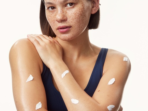 young girl in a top with creams all over her arms