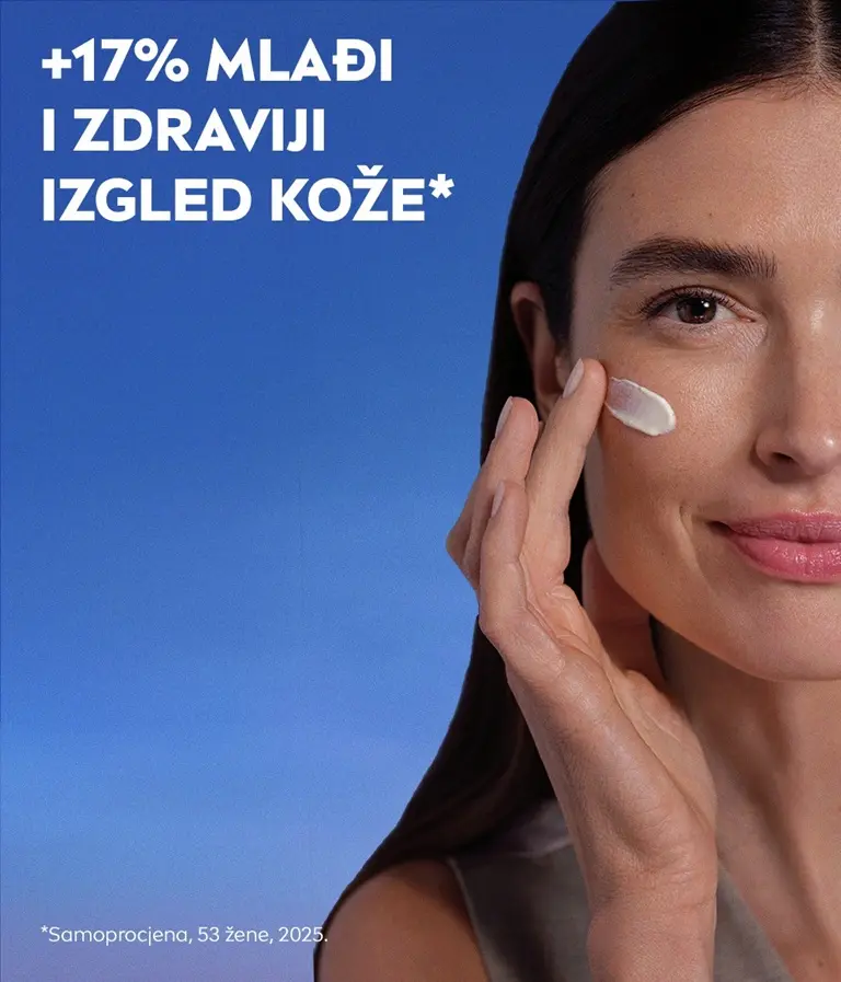 Žena gleda i blago se smiješi te pritom nanosi NIVEA CELLULAR Epigenetics noćnu kremu za pomlađivanje na obraz.