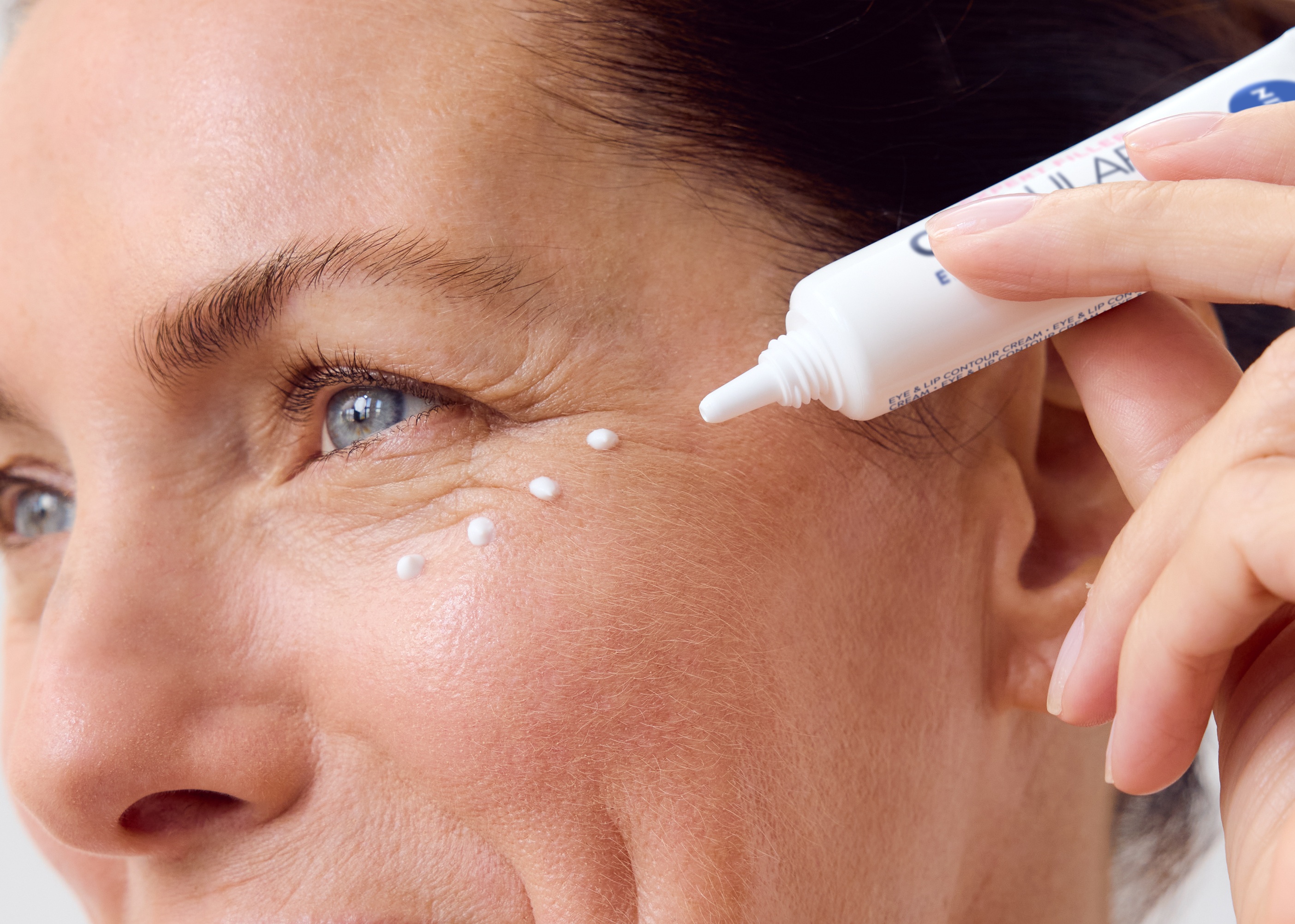 Woman using NIVEA Q10 Anti-Wrinkle POWER EXTRA FIRMING EYE CREAM
