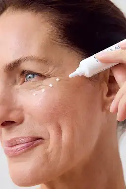 Woman using NIVEA Q10 Anti-Wrinkle POWER EXTRA FIRMING EYE CREAM
