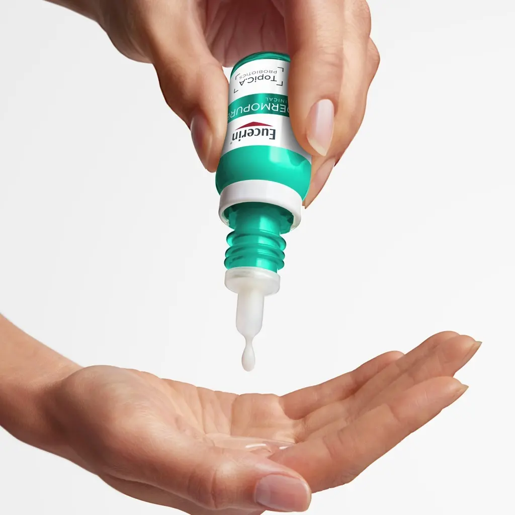 Eucerin Probiom8 TopiC.A drops being dispensed into the hand before mixing with moisturizer