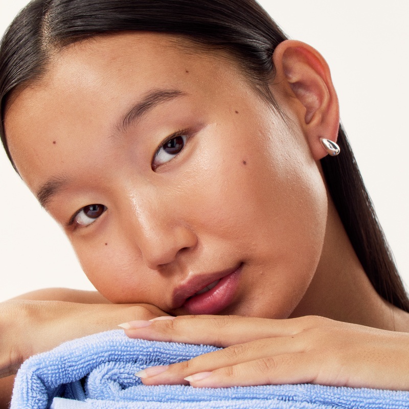 a young girl laying her head on a pile of towels