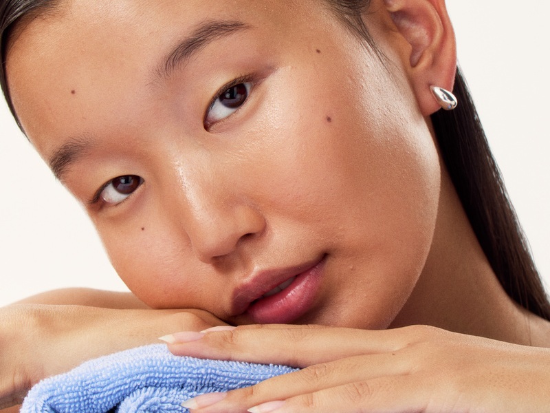 a young girl laying her head on a pile of towels
