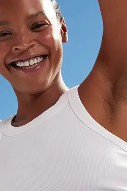 Woman smiling with their arms raised