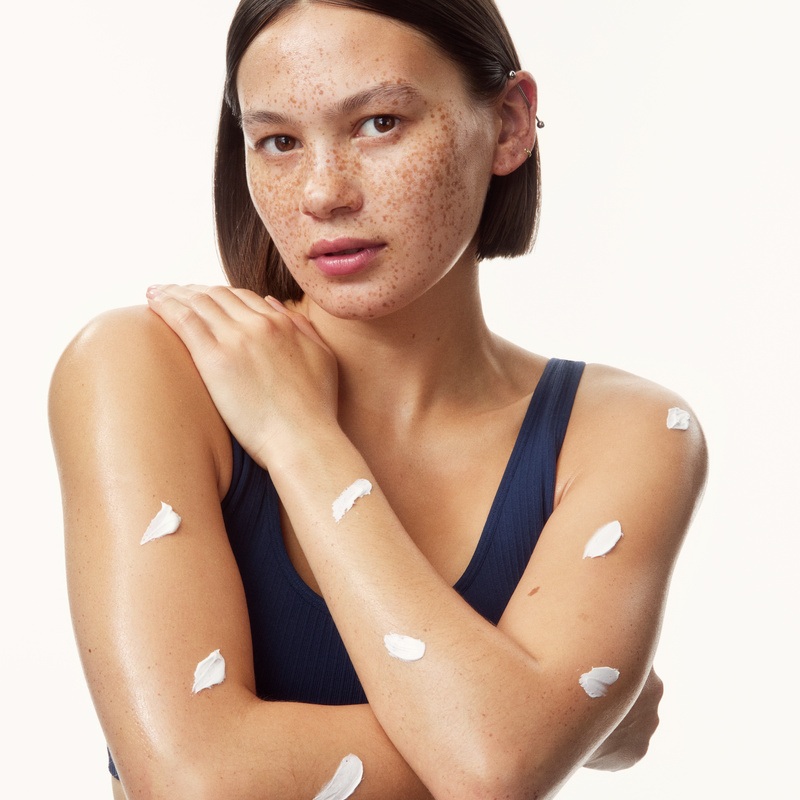 young girl in a top with creams all over her arms