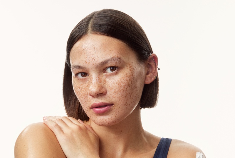 young girl in a top with creams all over her arms