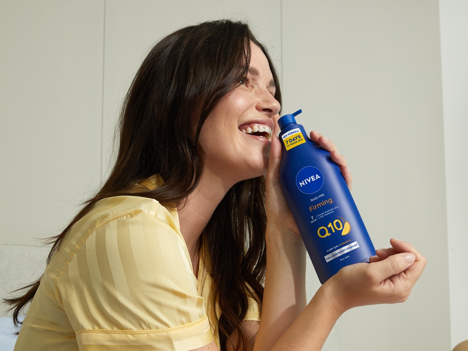 Young woman using Nivea Q10 Body Lotion