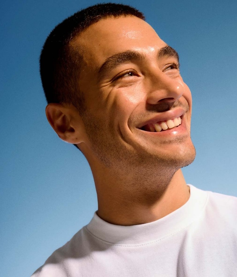 man with blemish free, clear skin looking happy and confident