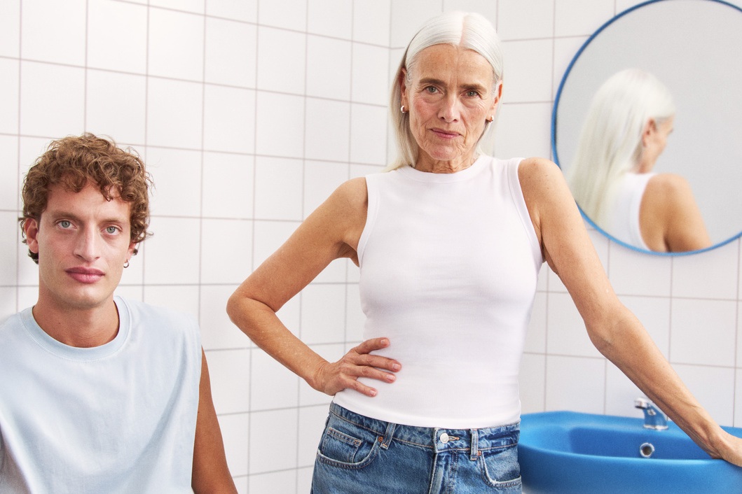 young man and a lady sitting in the bathroom looking to the camera