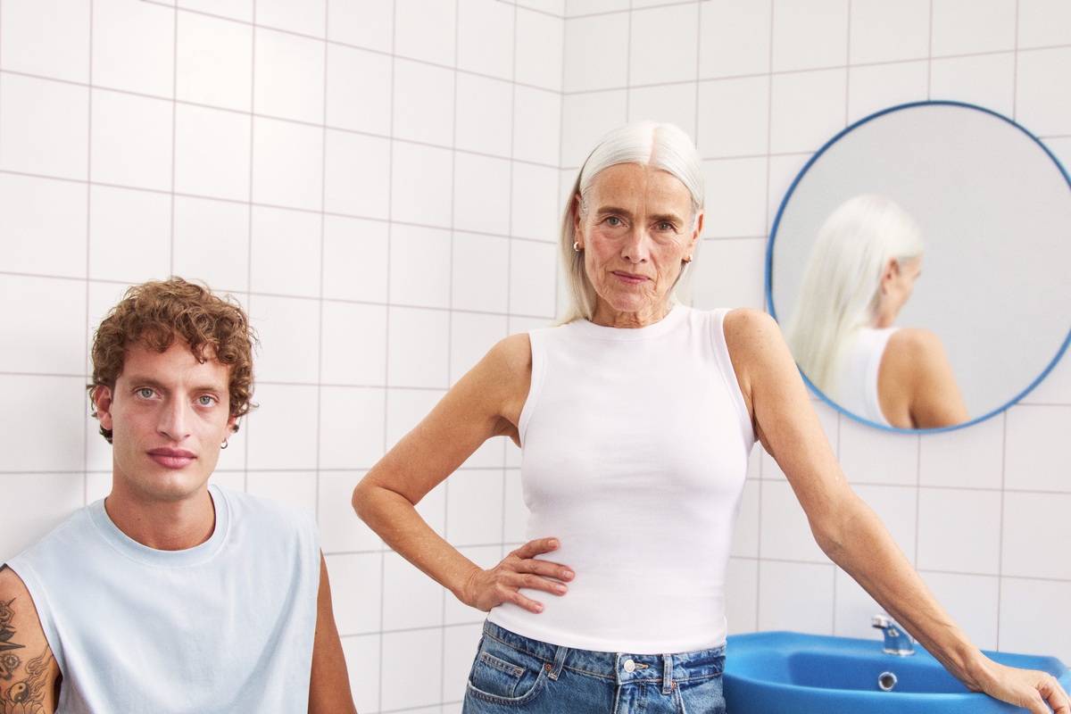 young man and a lady sitting in the bathroom looking to the camera