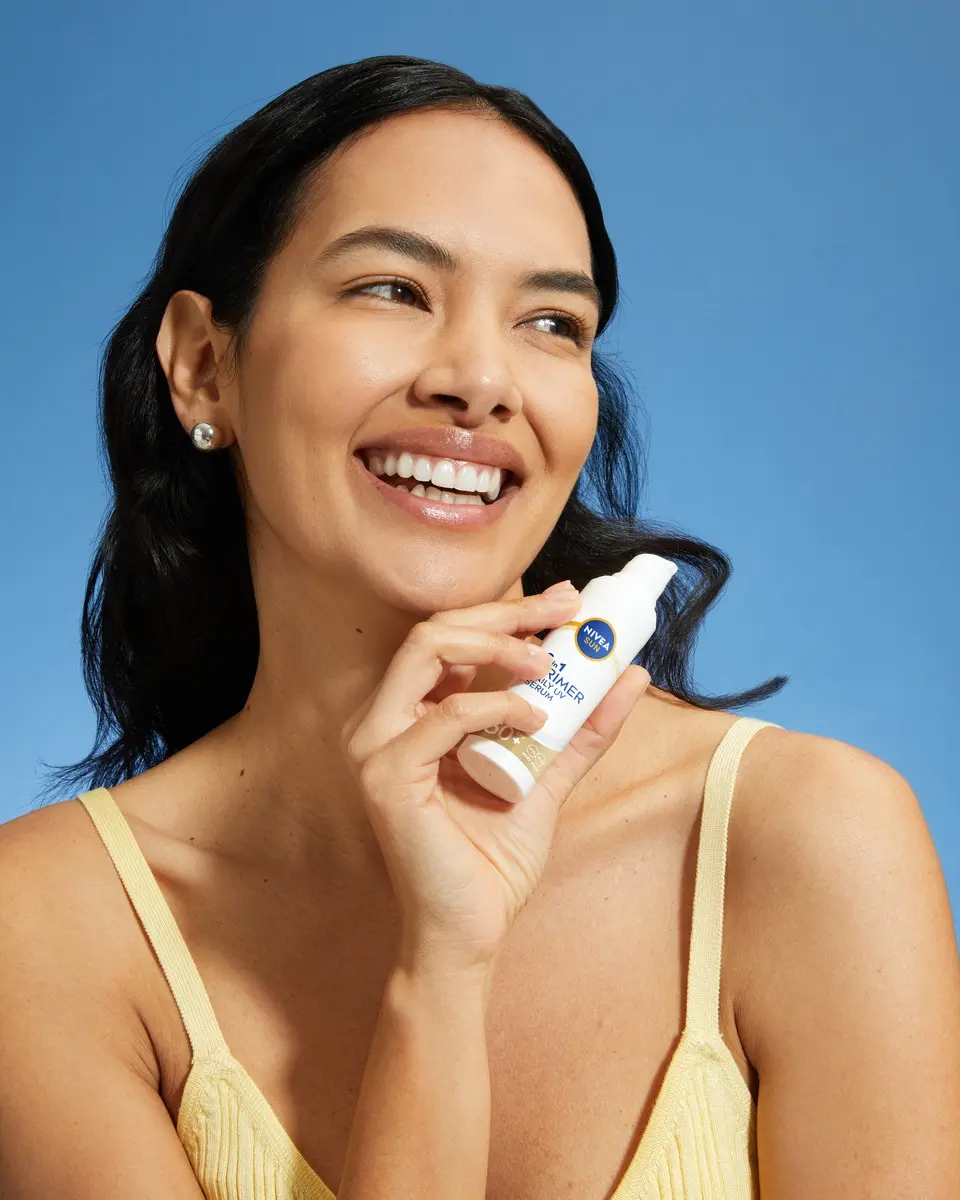 Young woman using NIVEA SUN 2In1 Primer UV Serum SPF 50+
