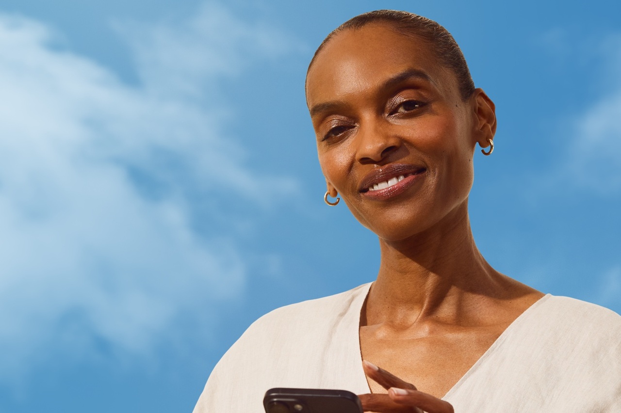 Smiling woman with phone beside EcoBeauty Score label and sustainable skincare message.