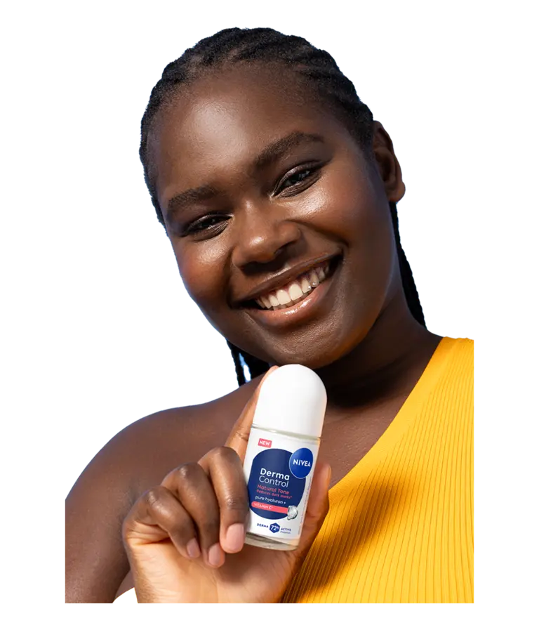 A young smiling woman tilts her head while holding up NIVEA Derma Control Natural Tone Deo Roll-On.