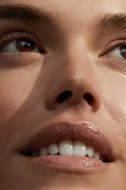 A before image of a young woman's face demonstrating the morning micellar water routine.